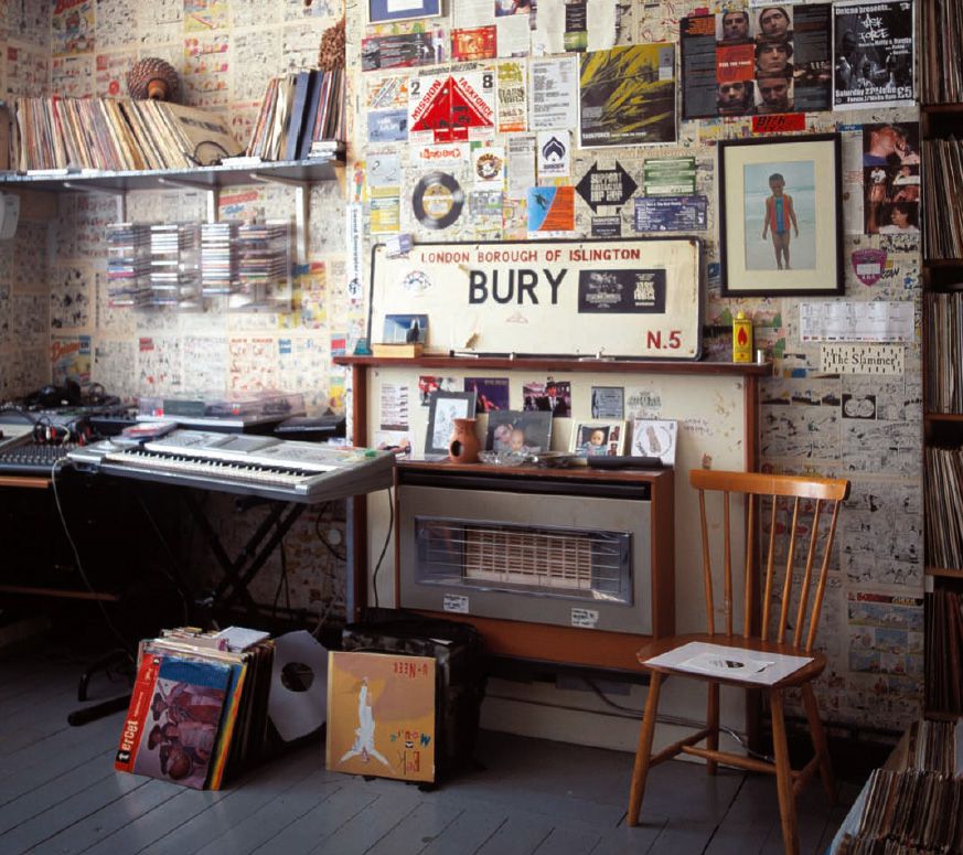 Gritty, urban-themed music studio with posters, records, and a keyboard.